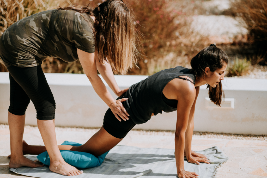 Teacher supporting a woman, using a block for support.